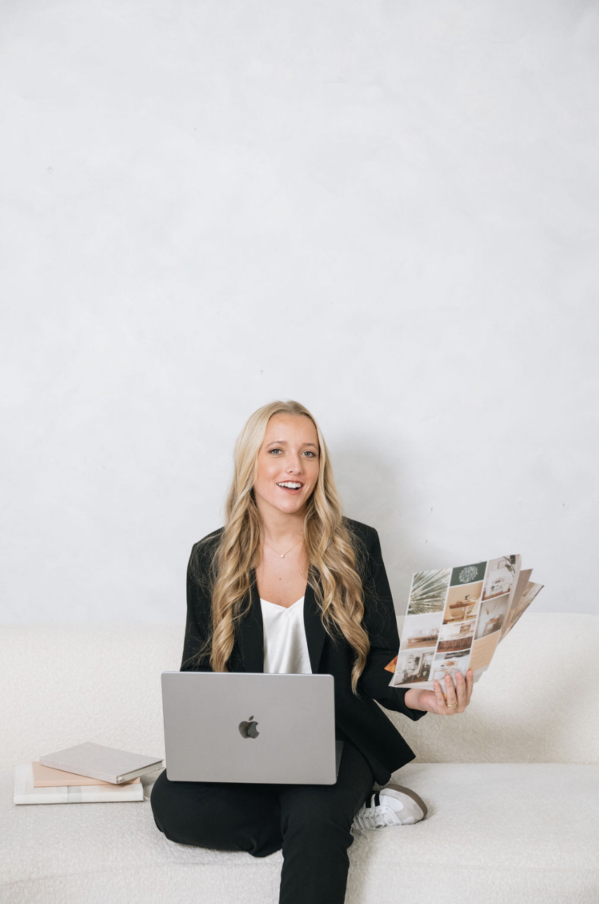 Founder of Banana River Marketing seated with a laptop, holding a printed brochure